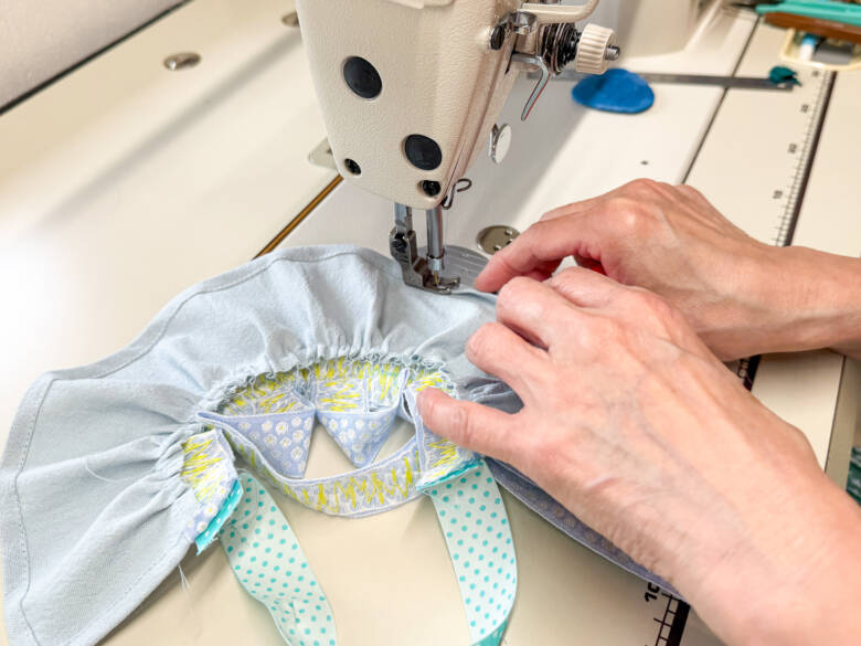 作業手順⑩ 三つ折りにした脇と裾をミシンで縫う様子