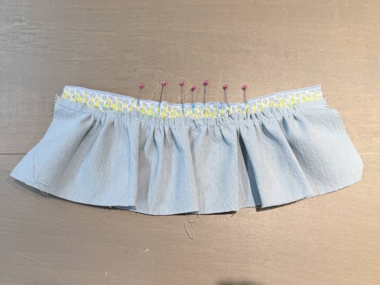 作業手順⑤ スカートが付いたリボンの上部裏側に、肩ひもをつける位置の目安として印をつけた様子。※今回は中心から両側に「1cm・2.5cm・2cm」の間隔で印をつけましたが、肩ひもの取り付け位置は、ぬいぐるみに合わせて調整してくださいね。