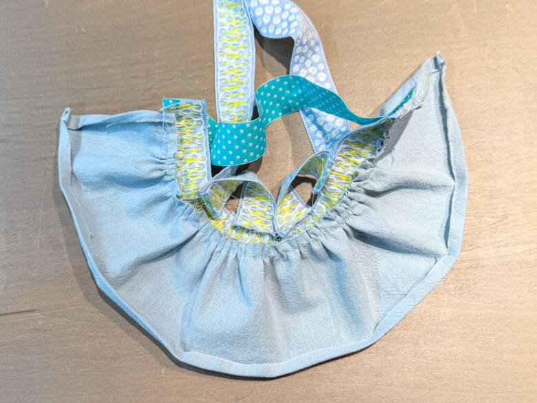 作業手順⑨ スカートの両脇は5mmの三つ折り、裾は7mmの三つ折りにして、それぞれアイロンでしっかり押さえる様子