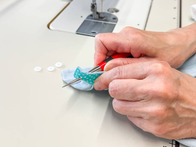 作業手順⑫ 最後に、スカートの後ろ側にスナップボタンを付けて完成する様子