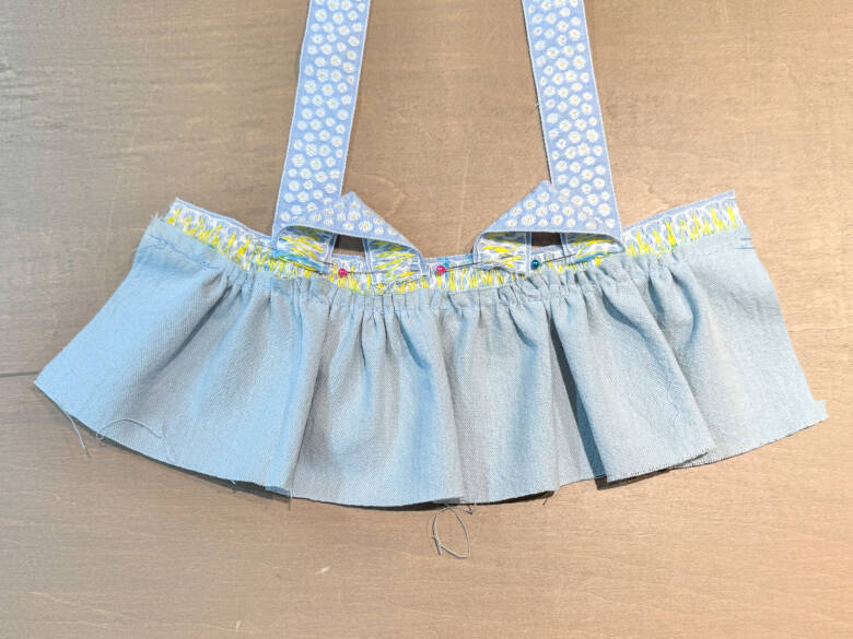 作業手順⑥ 肩ひも用のチロルリボンを、印の位置に1cm内側に差し込むように置き、待ち針でとめた様子