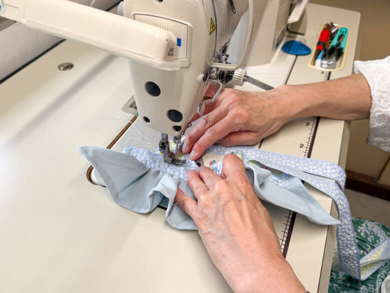 作業手順⑪ 胸のチロルリボンとリバーシブルリボンの周囲をぐるりと一周縫い、仕上げる様子