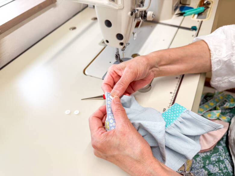 作業手順⑫ 最後に、スカートの後ろ側にスナップボタンを付けて完成する様子